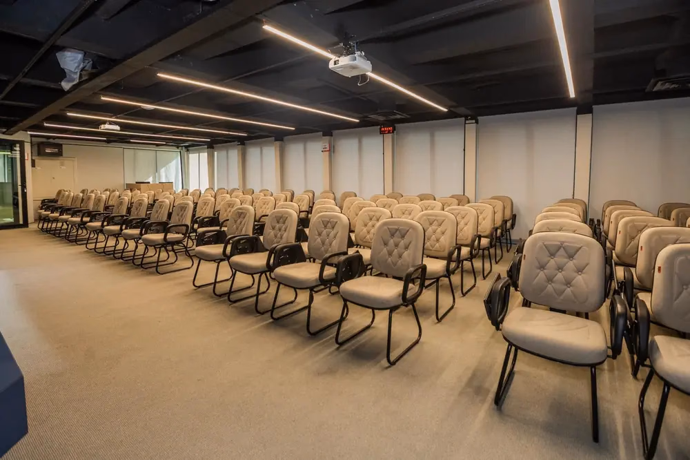 Auditório com cadeiras em fileiras preparado para congresso